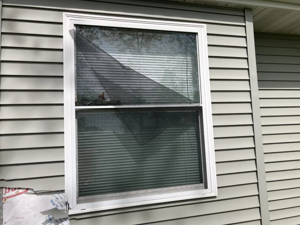 Back of the Home with Storm-Damaged Siding, Shingles, Gutters, and Downspouts in Tipton, Iowa