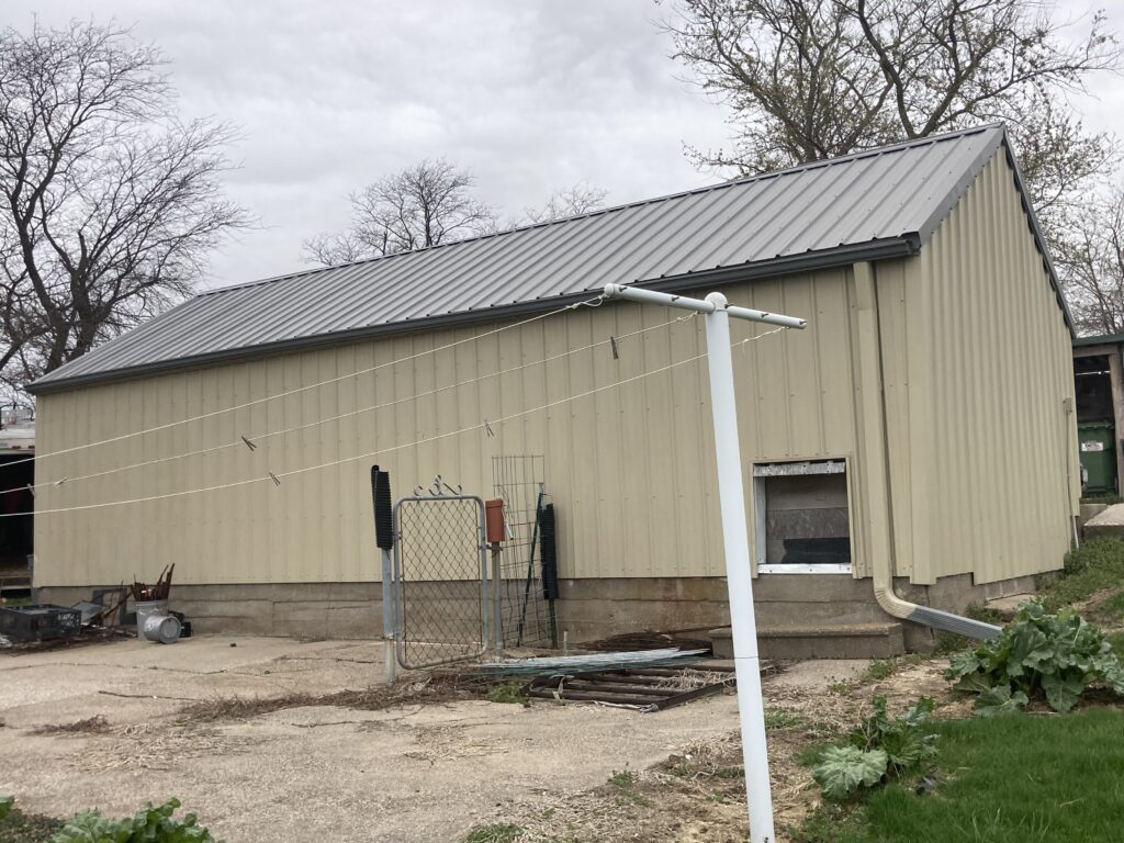 Back of the wind and hail-damaged metal roof in Wilton, Iowa
