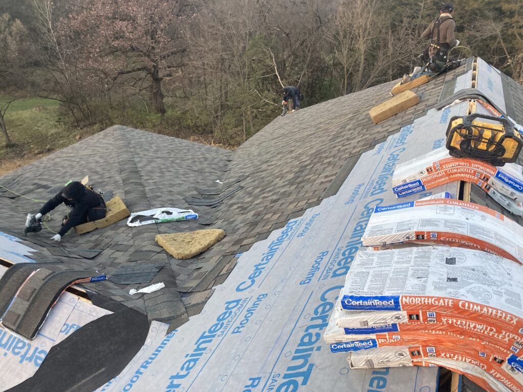 Crew installing shingles over ice and water shield, and synthetic underlayment on a house in Tipton, Iowa (working photo)