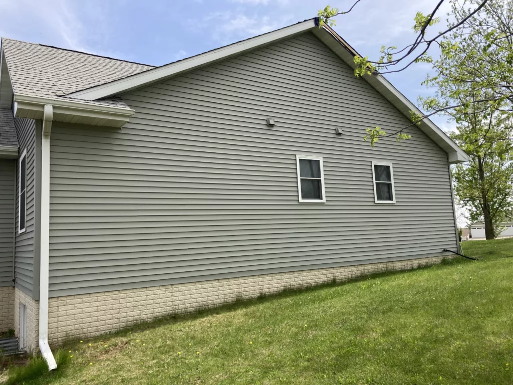Damage to siding, shingles, gutters, and downspouts on a home in Tipton, Iowa (side)