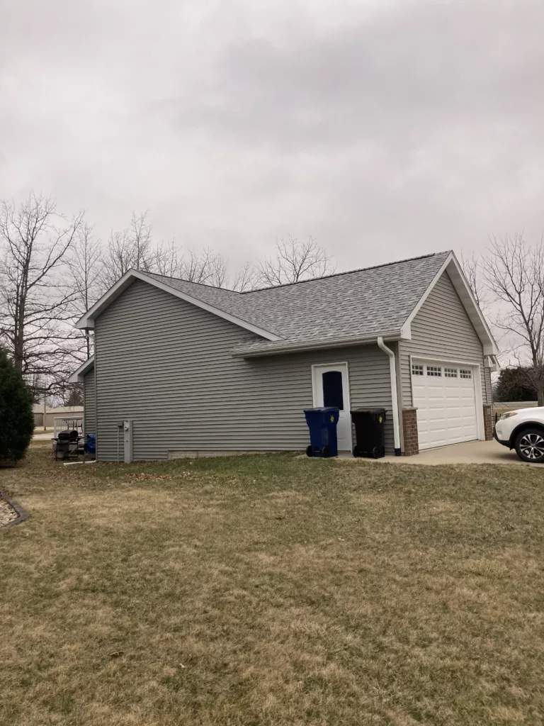 Finished view of replaced siding, shingles, gutters, and downspouts on a home in Tipton, Iowa (Garage)