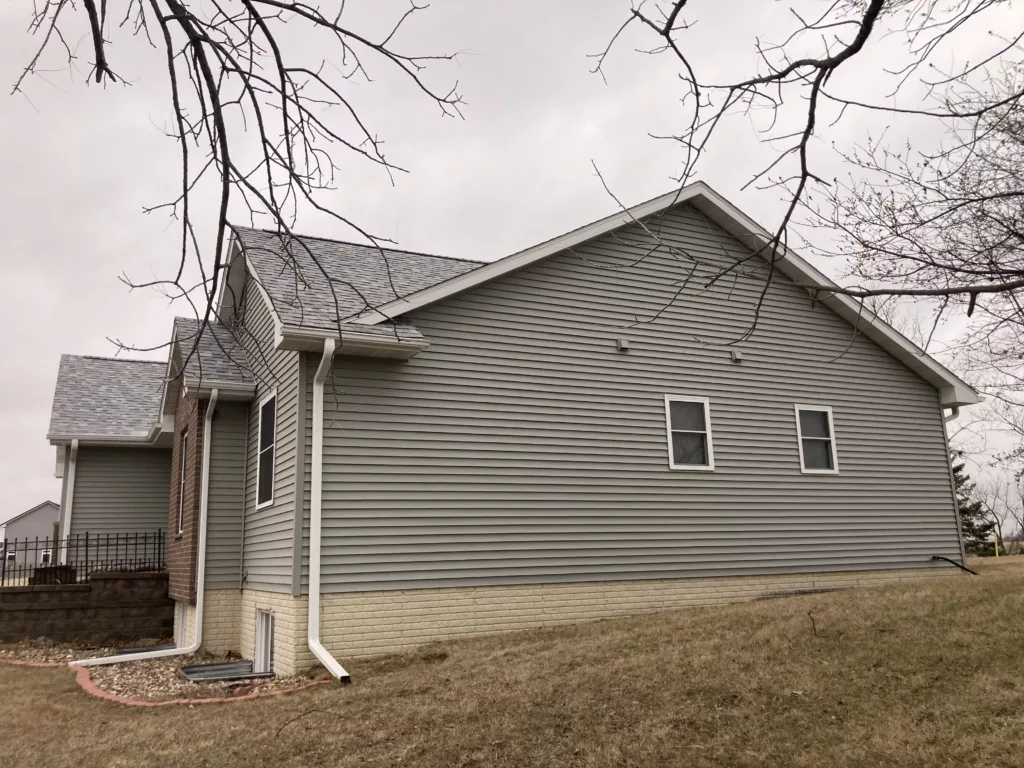 Finished view of replaced siding, shingles, gutters, and downspouts on a home in Tipton, Iowa (side)