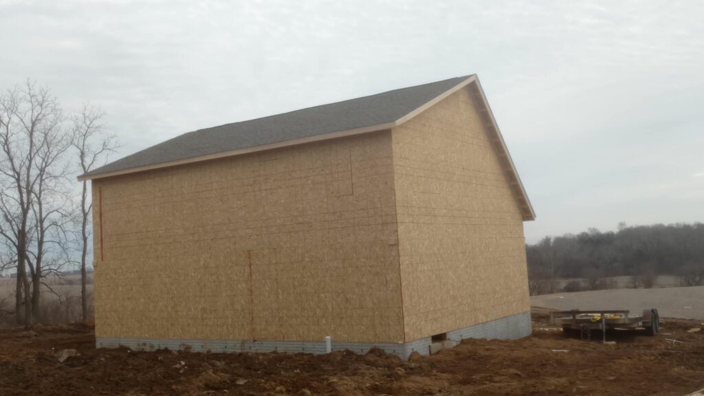 Roof shingles on new garage construction (back) on a farm in Tipton, Iowa