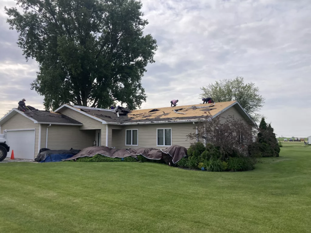 Crew removed the damaged roof that had missing asphalt shingles due to wind and hail damage roof in Stanwood, Iowa