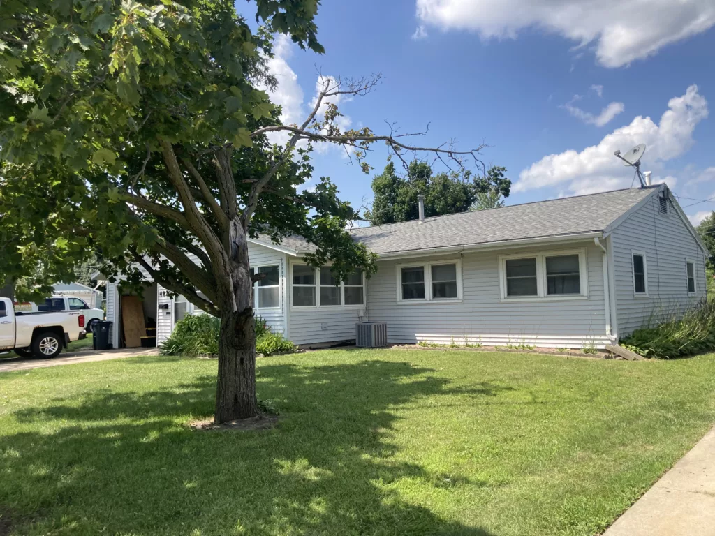 Before - Home with a damaged roof and an old satellite dish in Cedar Rapids, Iowa