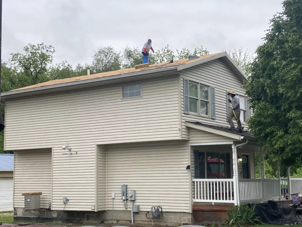 Hernandez KD Construction crew members are removing the age-related damaged roof in Davenport, Iowa