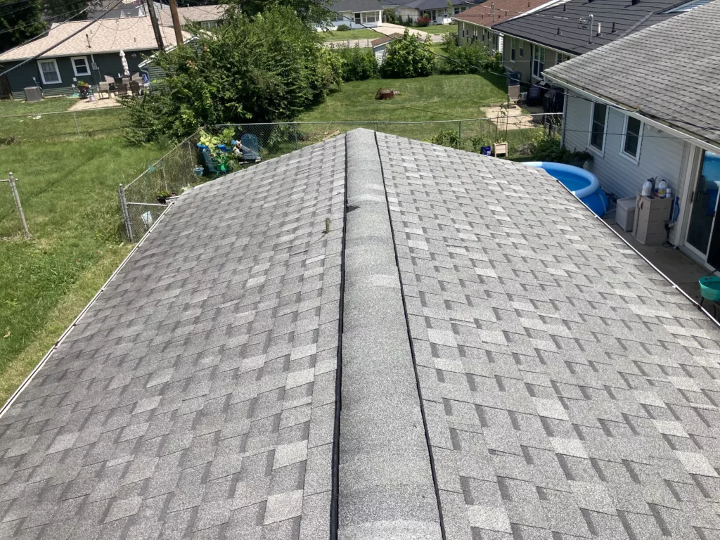 Ridge vent shingle damage with tree branch puncture of roof shingle on the garage in Cedar Rapids, Iowa