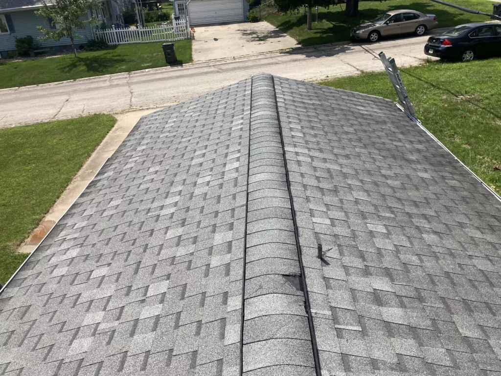 Ridge vent shingle damage with tree branch puncture of the shingle roof on the garage in Cedar Rapids, Iowa