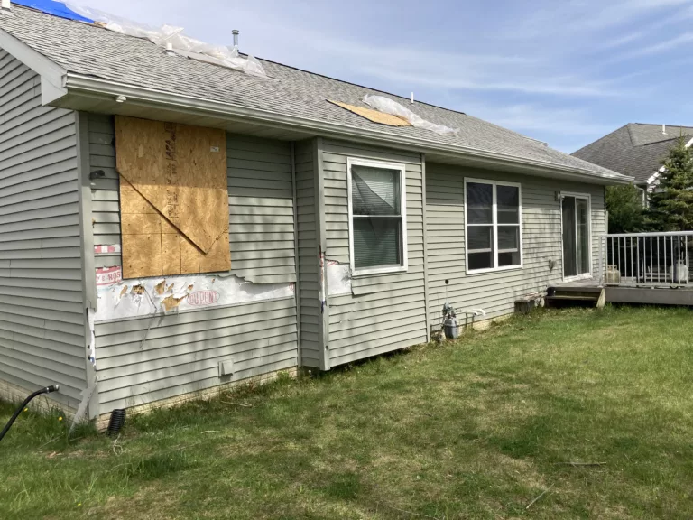 Home with Storm-Damaged Siding, Shingles, Gutters, and Downspouts in Tipton, Iowa