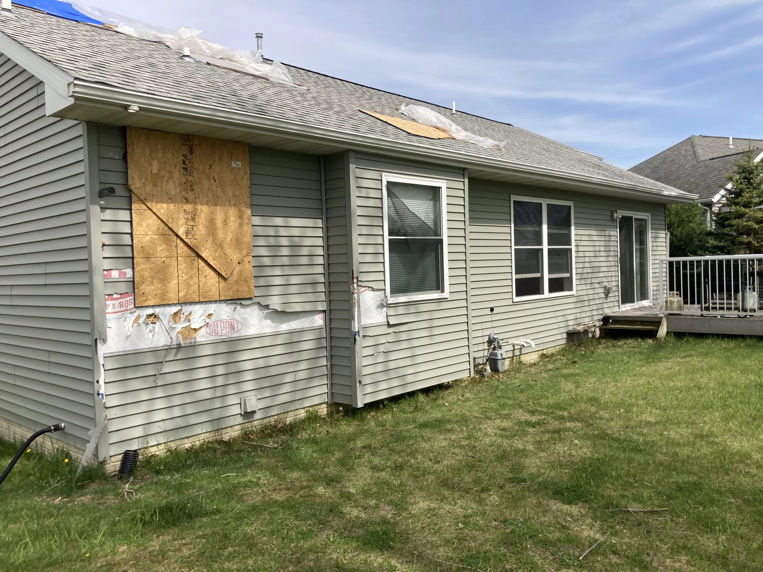 Home with Storm-Damaged Siding, Shingles, Gutters, and Downspouts in Tipton, Iowa